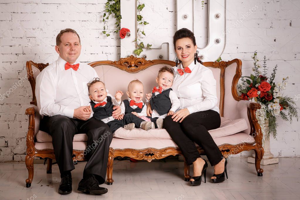 Big happy family: mother, father, triplets sons