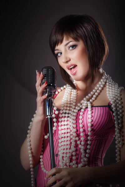 Bela cantora cantando com um microfone retro em estúdio — Fotografia de Stock