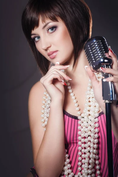 Vackra sångare sjunger med en retro mikrofon i studio — Stockfoto