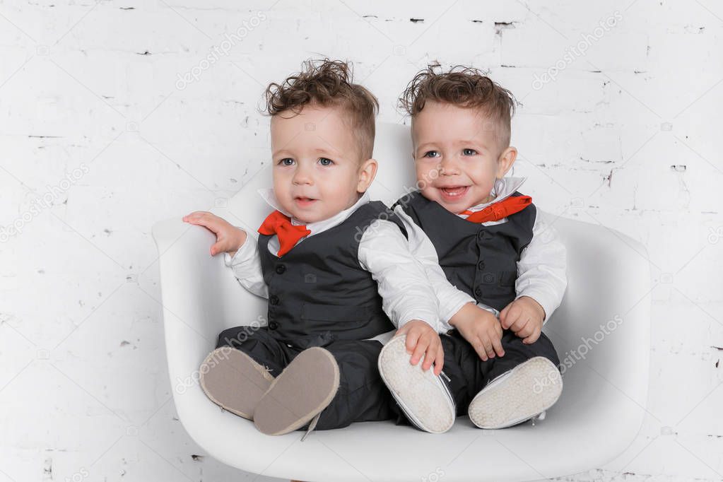 Portrait is sitting twin baby boys