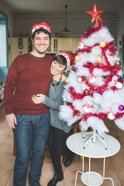 Pareja posando cerca del árbol de navidad — Foto de Stock