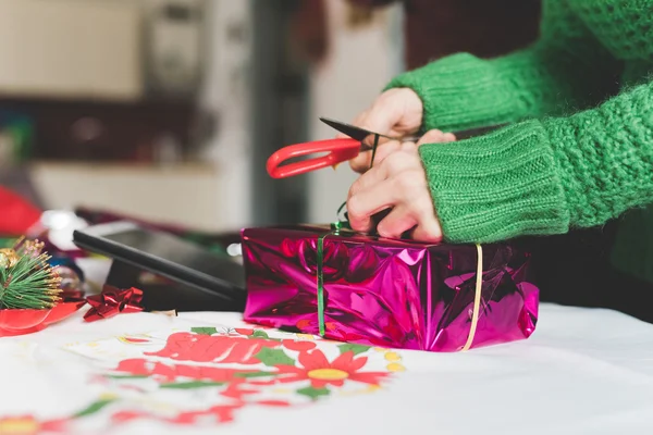 Frau verpackt ein Weihnachtsgeschenk — Stockfoto
