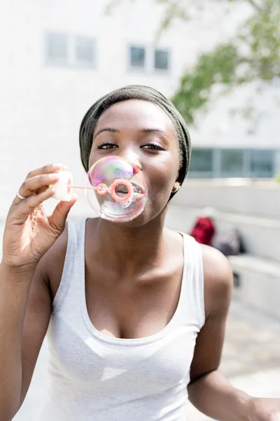 Mulher negra brincando com sabão bolha — Fotografia de Stock