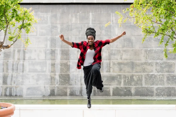 Vrouw buiten springen in de stad — Stockfoto