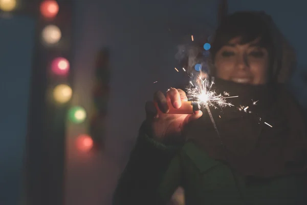 Woman celebrating holding sparkler — Stock Photo, Image