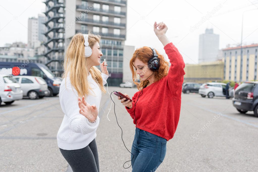 women listening music with headphones