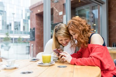 kadın otururken smartphone kullanarak bar