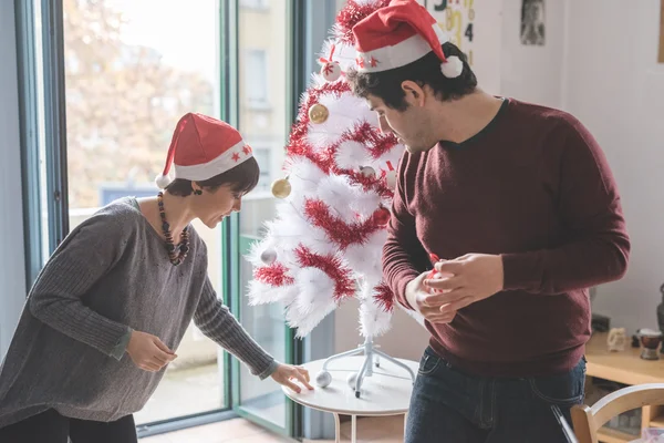 クリスマスツリーを飾るカップル — ストック写真