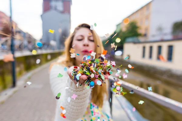 Mujer soplando confeti de carnaval —  Fotos de Stock