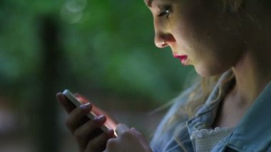 Smartphone gece şehirde kullanan kadın