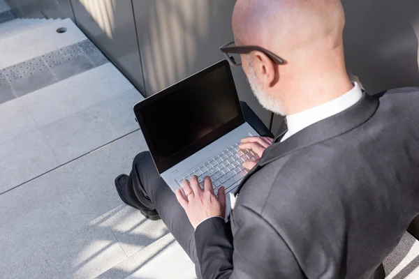 Businessman using notebook outdoor — Stock Photo, Image