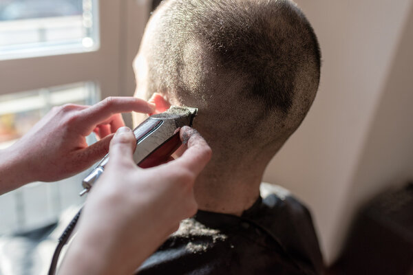 barber hand cutting hair using razor