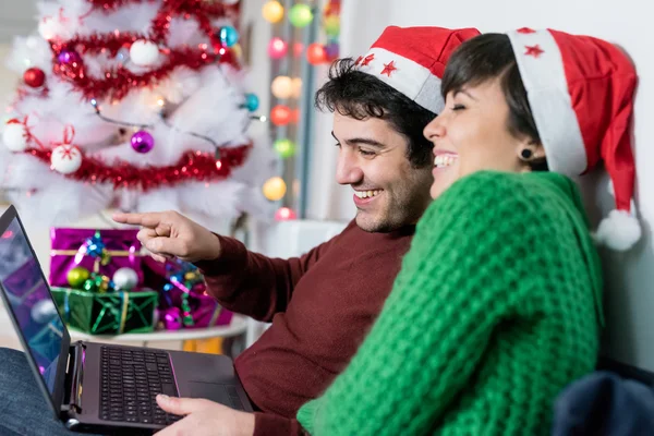 Par med jultomten hatt med hjälp av dator — Stockfoto