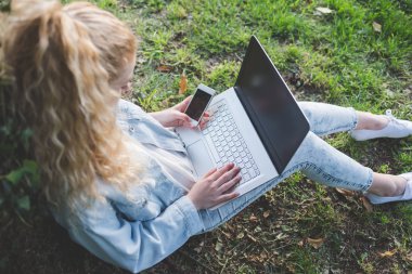 woman on he grass using notebook