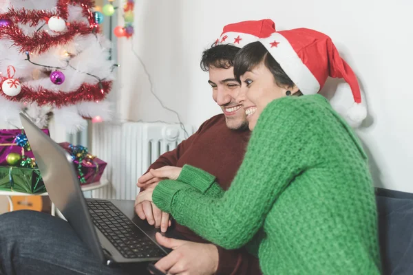 Par på soffan med hjälp av dator — Stockfoto