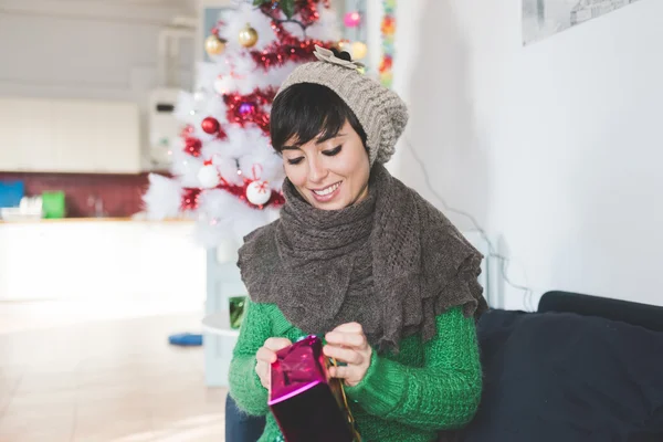 Mulher desembrulhando um presente de Natal — Fotografia de Stock