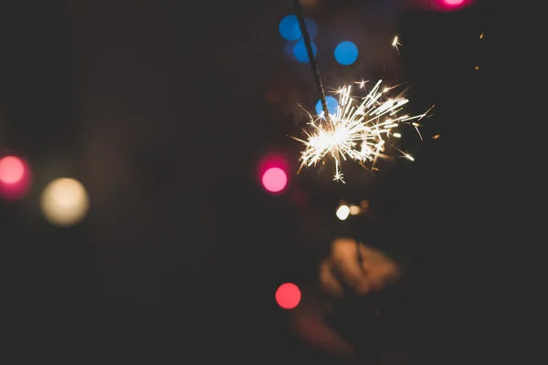 Woman celebrating holding a sparkler — Stock Photo, Image