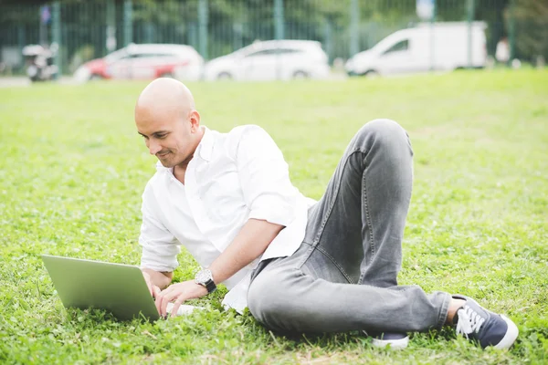 Empresário no parque da cidade usando laptop — Fotografia de Stock