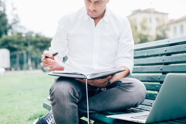 Uomo d'affari su una panchina utilizzando notebook — Foto Stock
