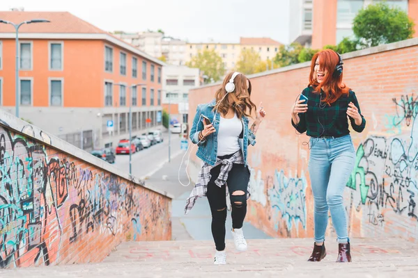 Mujeres bailando en la ciudad escuchando música — Foto de Stock