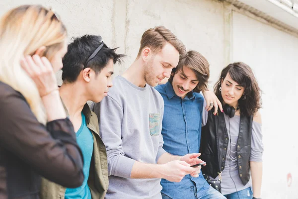 Amigos apoyados en una pared charlando — Foto de Stock