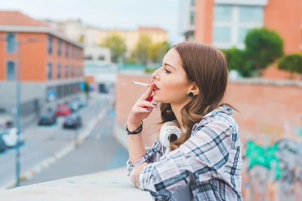 Woman leaning on handrail smoking — Stock fotografie