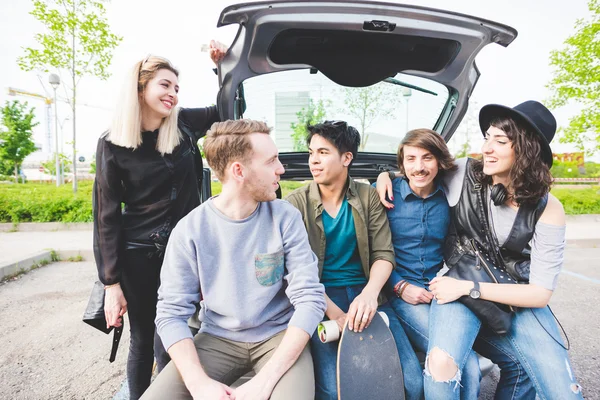 Amigos sentados en un maletero de un coche — Foto de Stock