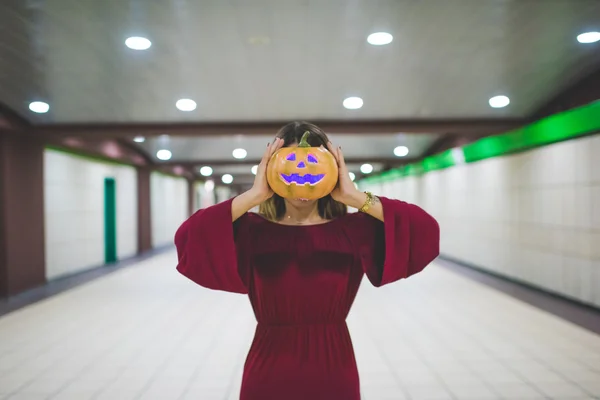 Woman indoor with pumpkin face — Stock Photo, Image