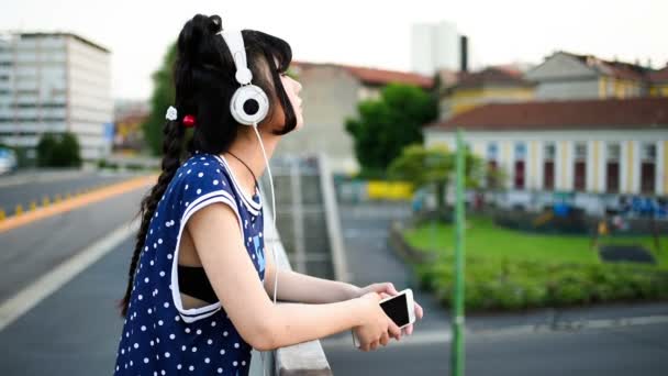 Mujer oriental escuchando música con auriculares — Vídeos de Stock