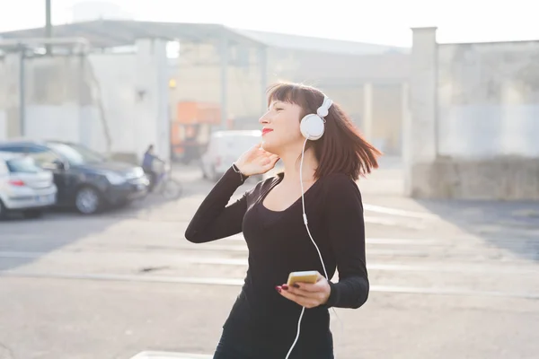 Východní žena poslech hudby se sluchátky — Stock fotografie