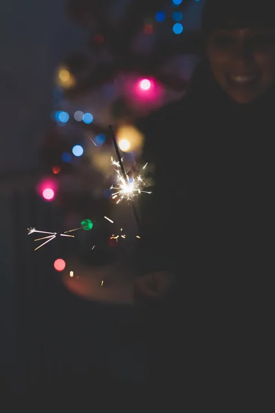 Woman celebrating holding sparkler — Stock Photo, Image