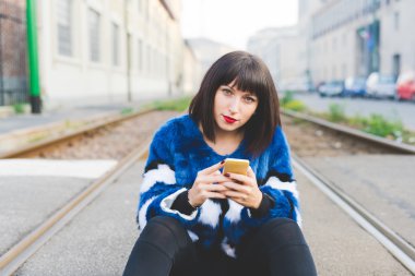 Smartphone tutan katta oturan kadın