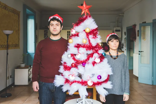 Pár pózuje u vánočního stromu — Stock fotografie