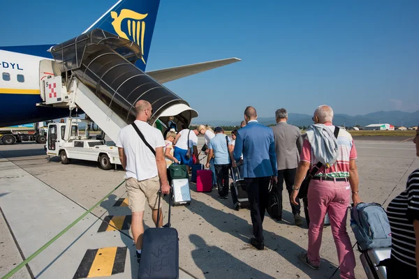 Pessoas que transportam bagagem embarque no avião da Ryanair — Fotografia de Stock