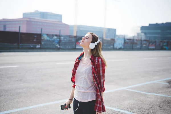 Mujer en la ciudad escuchando música — Foto de Stock