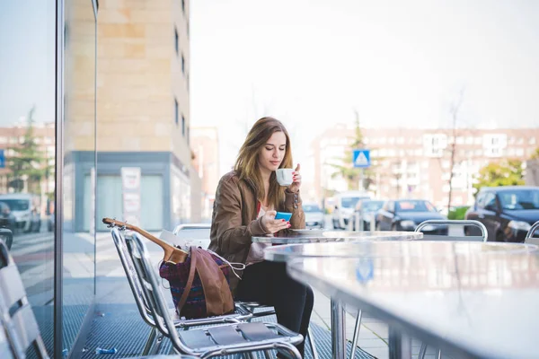 Femme assise au bar ayant café — Photo