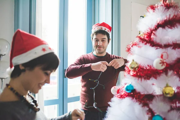 Man och kvinna dekorera julgran — Stockfoto