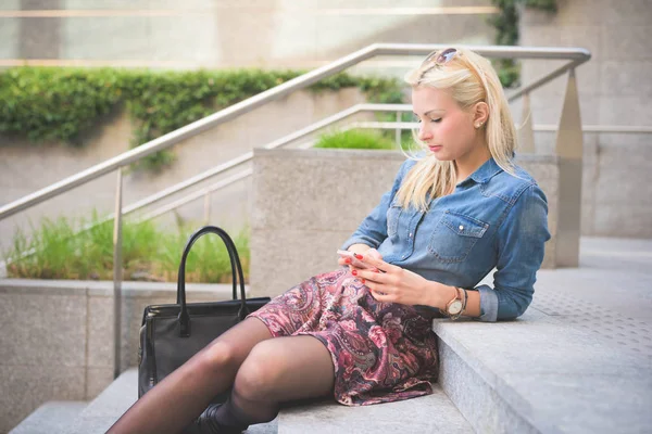Girl on staircase using smartphone — Stock Photo, Image