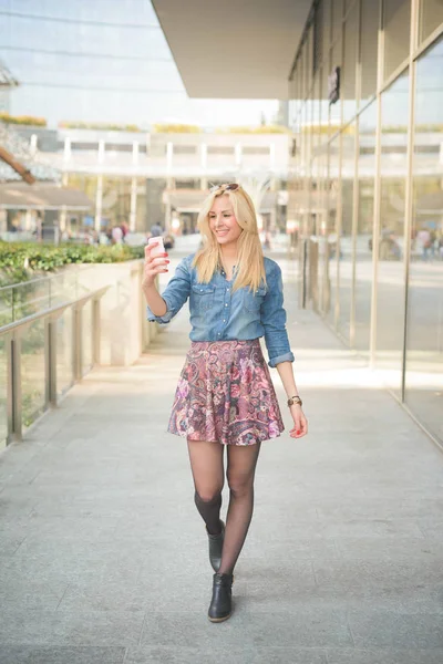 Flicka med en smartphone som tar en selfie — Stockfoto
