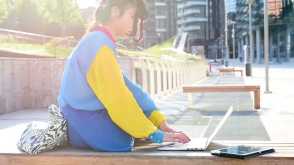 Vrouw in de stad terug licht met behulp van computer — Stockvideo