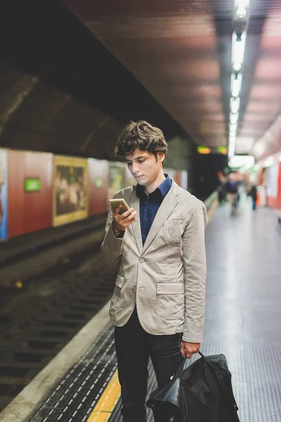 Businessman using smartphone in subway — Stock Photo, Image