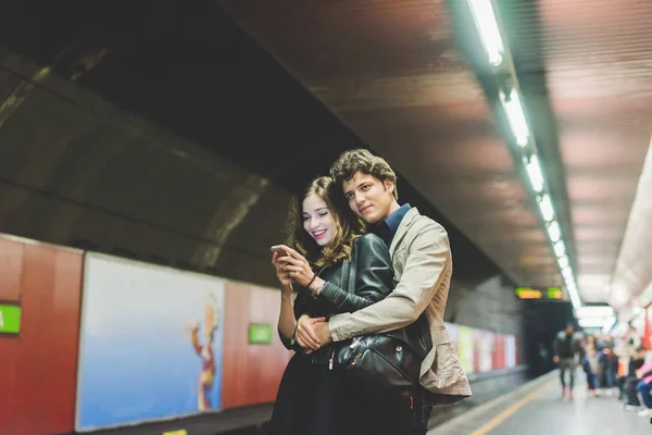 Casal apaixonado usando smartphone no metrô — Fotografia de Stock