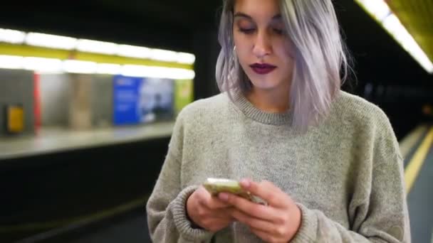 femme attente tube dans souterrain, tenant smartphone 