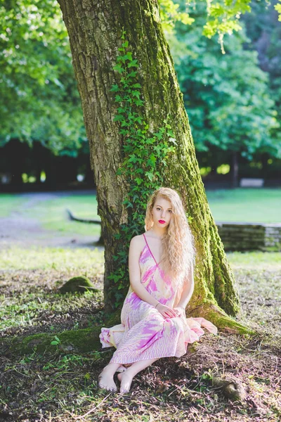 Женщина в розовом платье в лесу — стоковое фото