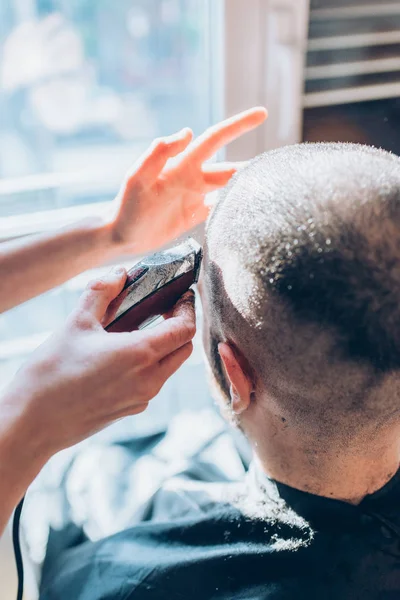 Woman barber cutting hair using razor