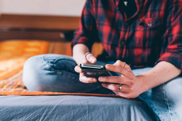 Kvinna som ligger på sängen med hjälp av smartphone — Stockfoto