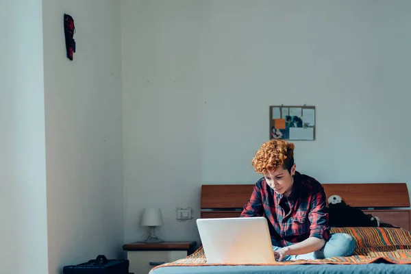 Vrouw liggend op bed met behulp van laptop — Stockfoto