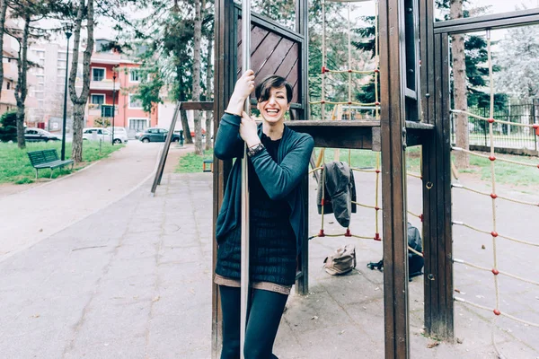 Mujer divirtiéndose en un parque infantil — Foto de Stock