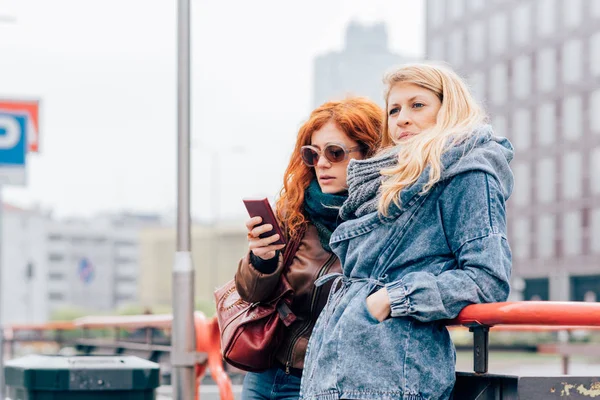 Les femmes utilisant un smartphone en ville — Photo