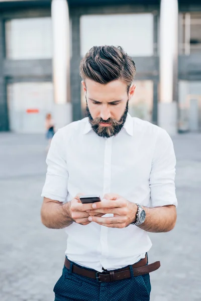 Hombre de negocios barbudo sosteniendo smartphone — Foto de Stock